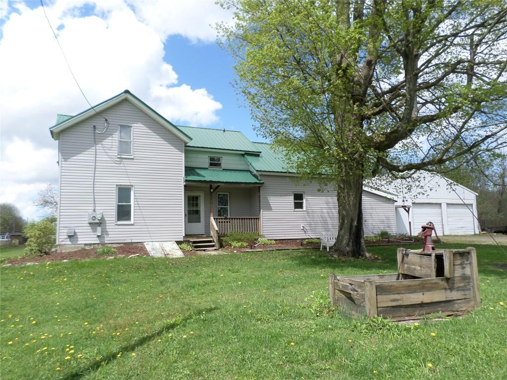 5328 Knoyle Rd, Erie, PA 16510 - back of property featuring covered porch, a garage, metal roof, and a lawn