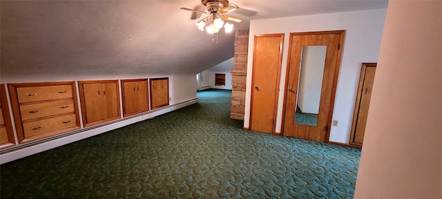 additional living space with vaulted ceiling, dark carpet, and a baseboard heating unit