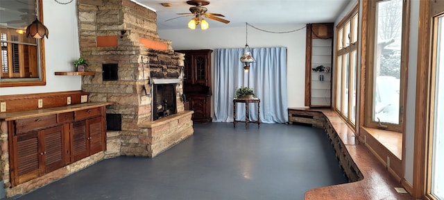 living room featuring ceiling fan, a healthy amount of sunlight, and a fireplace