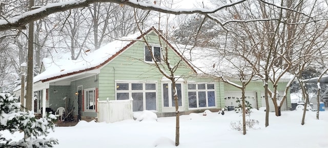 snow covered property featuring a garage