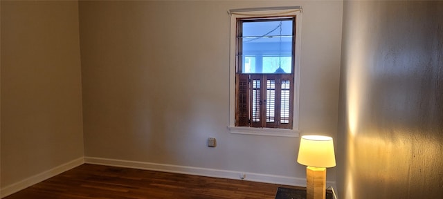 unfurnished room with dark wood-type flooring