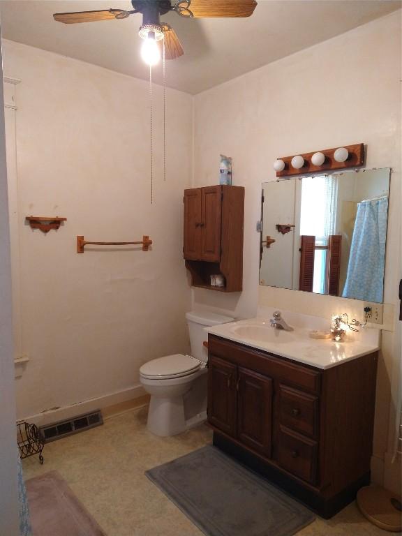 bathroom with visible vents, baseboards, toilet, ceiling fan, and vanity