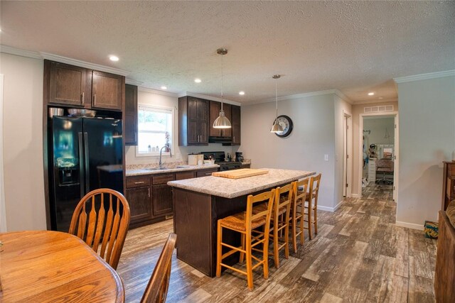 134 Primrose Ln, Edinboro, PA 16412 - kitchen with black fridge, stove, dark brown cabinetry, wood finished floors, and a kitchen island
