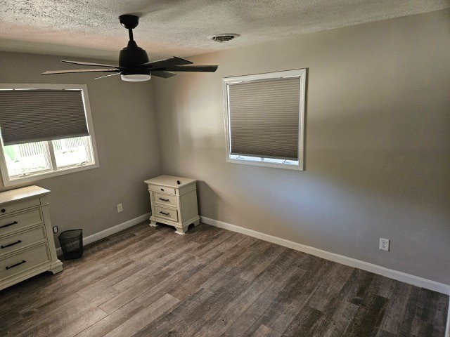 1925 N Mill St, North East, PA 16428 - unfurnished bedroom featuring a textured ceiling, baseboards, dark wood-style floors, and a ceiling fan