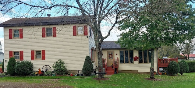 rear view of house with a wooden deck and a yard