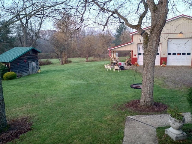 view of yard featuring a garage and an outdoor structure