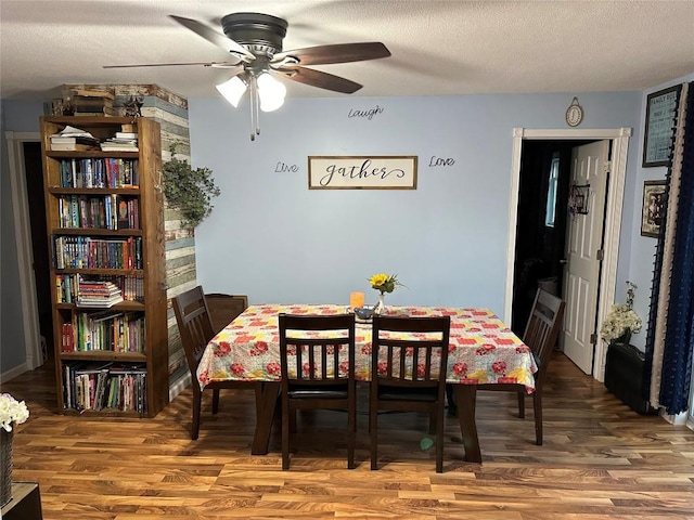 dining space featuring hardwood / wood-style floors, a textured ceiling, and ceiling fan