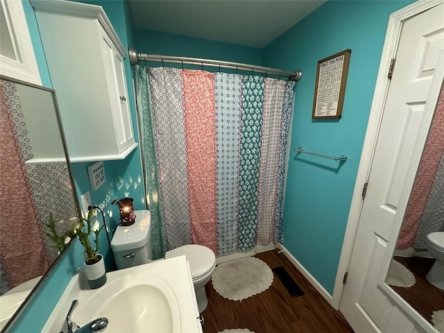 bathroom featuring curtained shower, hardwood / wood-style flooring, sink, and toilet