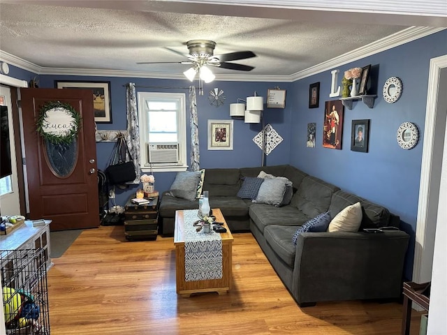 living room with hardwood / wood-style flooring, ceiling fan, ornamental molding, and a textured ceiling