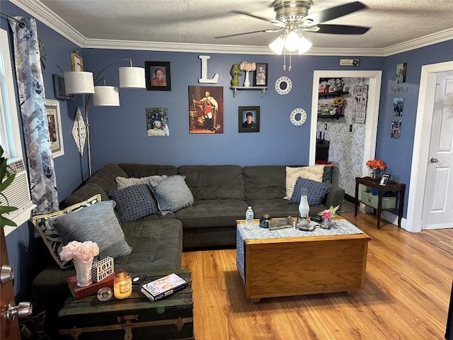 living room featuring wood-type flooring, a textured ceiling, ceiling fan, and crown molding