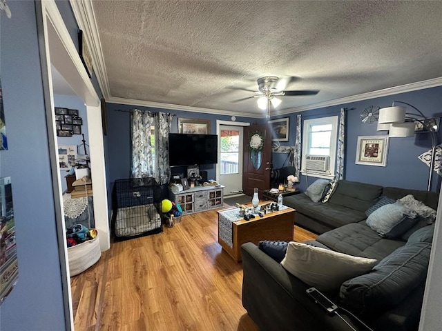 living room featuring ceiling fan, crown molding, hardwood / wood-style floors, cooling unit, and a textured ceiling