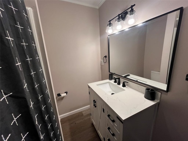 bathroom with hardwood / wood-style floors, vanity, and ornamental molding