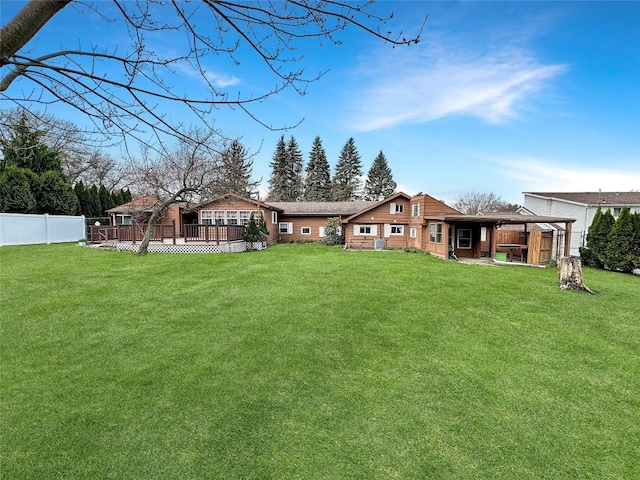 back of house featuring a fenced backyard and a lawn