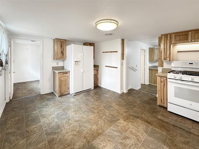 kitchen featuring white appliances, light countertops, baseboards, stone finish floor, and visible vents