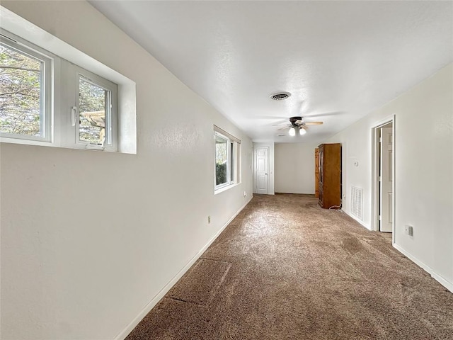 spare room featuring baseboards, visible vents, carpet floors, and ceiling fan