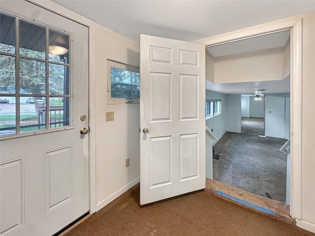 doorway with ceiling fan, baseboards, carpet flooring, and plenty of natural light