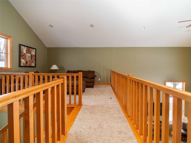 hall featuring light colored carpet and lofted ceiling