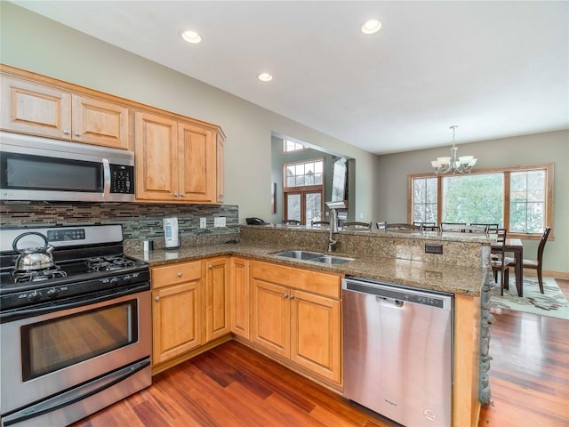 kitchen featuring a healthy amount of sunlight, appliances with stainless steel finishes, sink, and kitchen peninsula