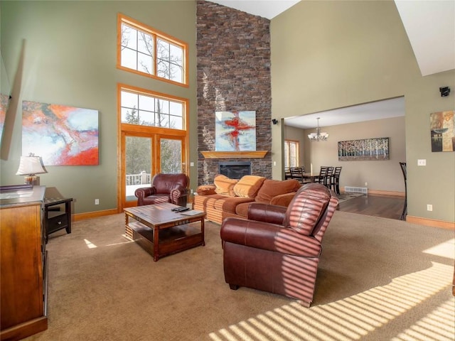 carpeted living room with an inviting chandelier, a stone fireplace, and high vaulted ceiling