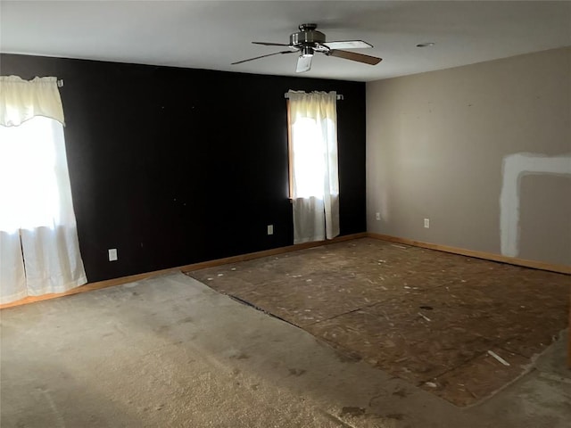 empty room featuring ceiling fan and baseboards