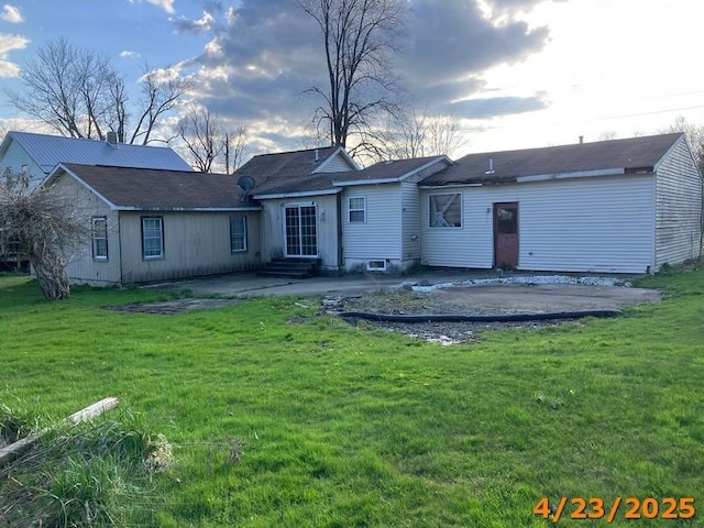 rear view of house with a yard, a patio area, and entry steps