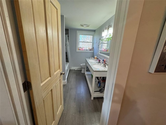 bathroom with vanity, visible vents, toilet, wood finished floors, and baseboards