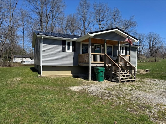 view of front facade with a porch, metal roof, a front yard, and crawl space