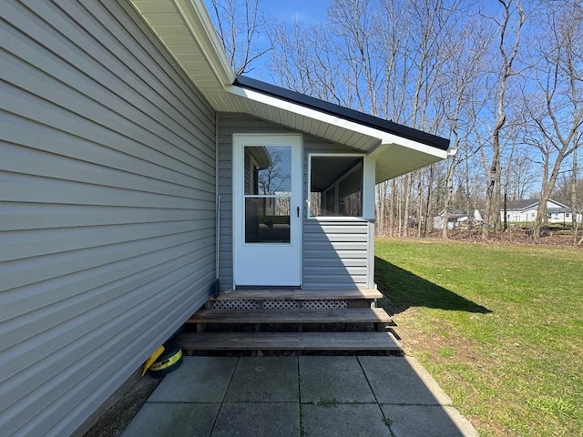 view of exterior entry with a yard