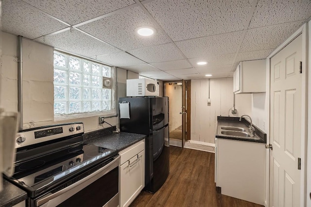 kitchen featuring electric stove, sink, dark wood-type flooring, white cabinets, and black fridge