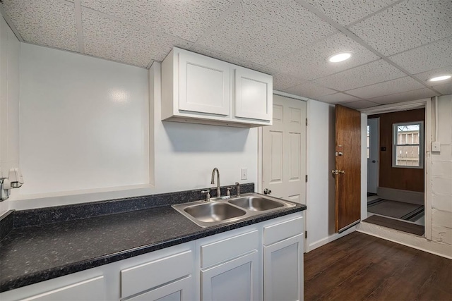 kitchen featuring white cabinetry, sink, dark wood-type flooring, and a paneled ceiling