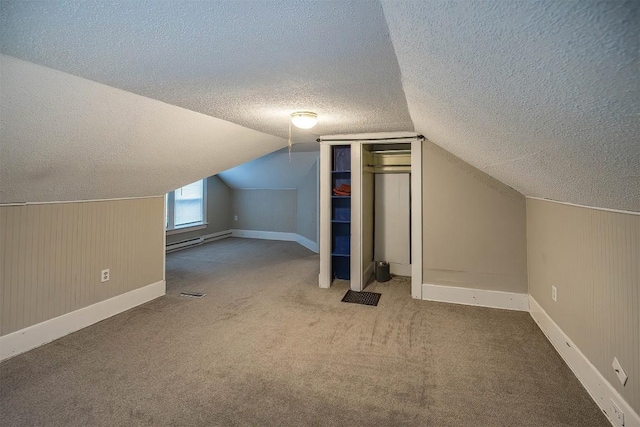 additional living space featuring lofted ceiling, wooden walls, carpet flooring, a textured ceiling, and a baseboard radiator