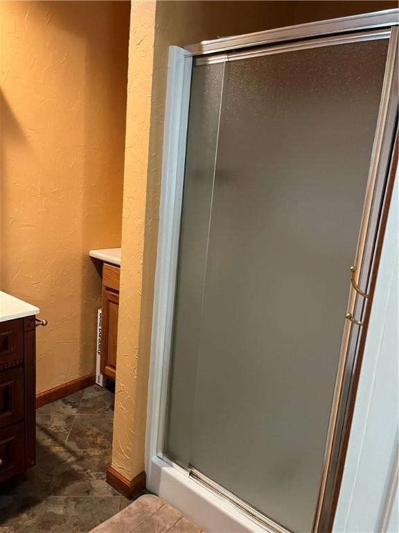 bathroom with a shower with door and vanity