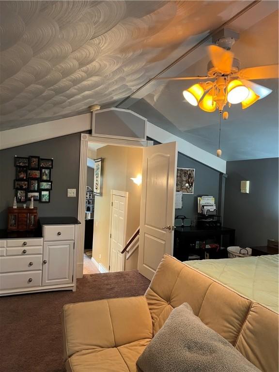 carpeted living room featuring ceiling fan and lofted ceiling