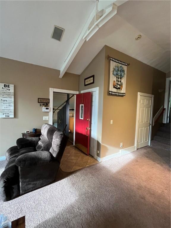 living room featuring light carpet and lofted ceiling with beams