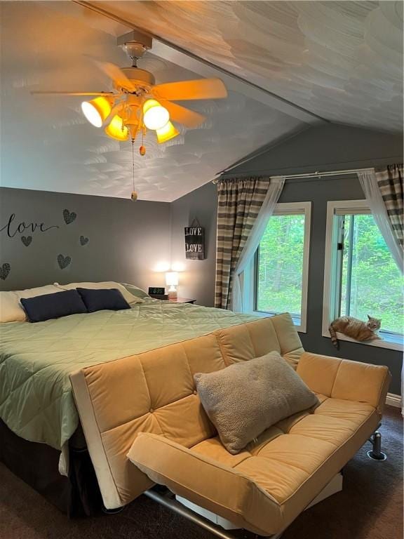 carpeted bedroom with ceiling fan and vaulted ceiling