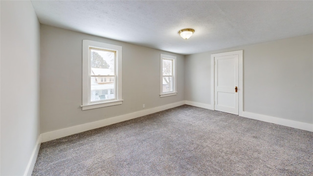 carpeted spare room featuring a textured ceiling