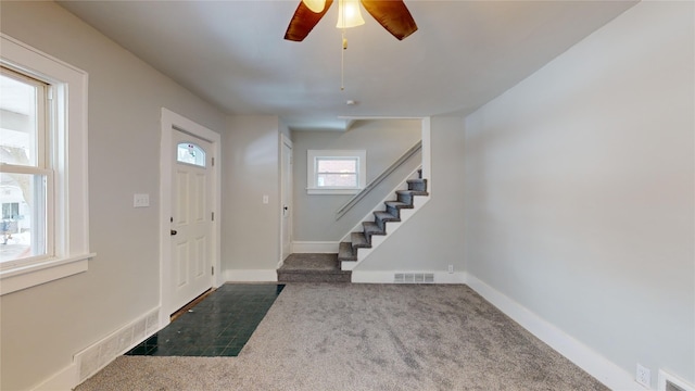 carpeted entryway featuring ceiling fan