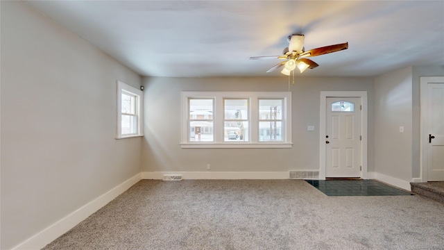 foyer entrance with dark colored carpet and ceiling fan