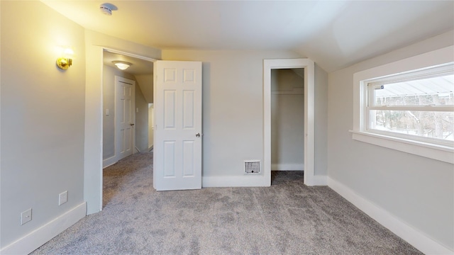 unfurnished bedroom featuring light colored carpet, lofted ceiling, and a closet