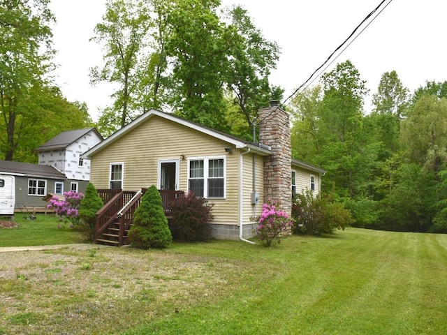 1429 Quick Dr, Espyville, PA 16424 - rear view of property featuring a chimney, a yard, and a wooden deck