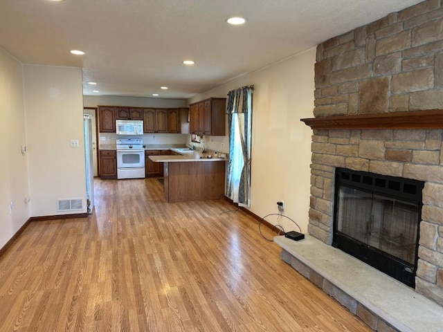 1429 Quick Dr, Espyville, PA 16424 - kitchen with white appliances, light countertops, light wood finished floors, a stone fireplace, and baseboards