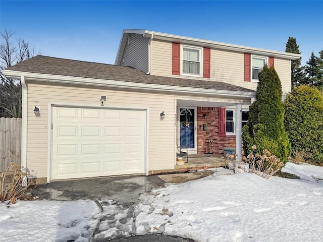 traditional home with an attached garage, a shingled roof, aphalt driveway, and brick siding