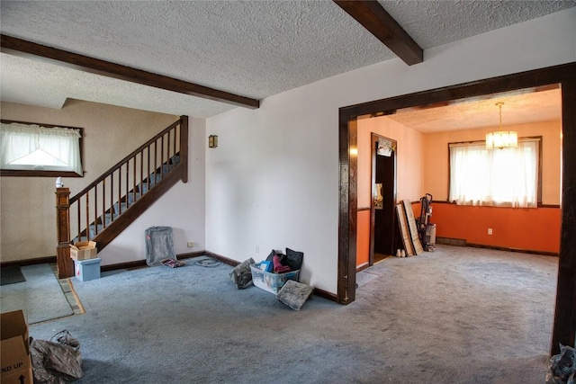 1219 W 32nd St, Erie, PA 16508 - unfurnished living room with a textured ceiling, beam ceiling, carpet, stairs, and a chandelier