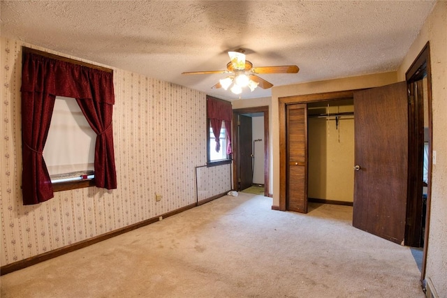 1219 W 32nd St, Erie, PA 16508 - unfurnished bedroom with carpet, a closet, a textured ceiling, a ceiling fan, and wallpapered walls