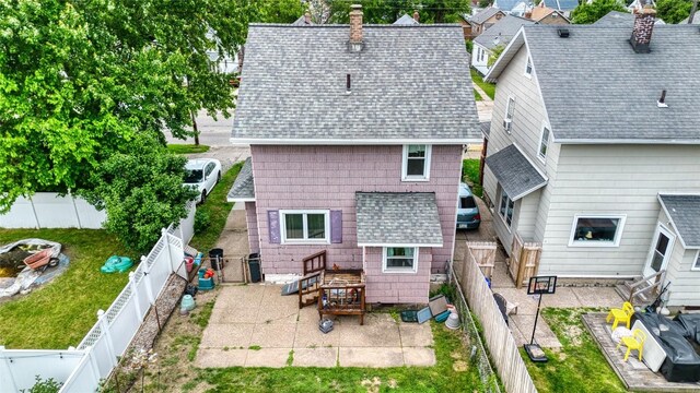 1219 W 32nd St, Erie, PA 16508 - back of property featuring a patio, a chimney, a shingled roof, and a fenced backyard