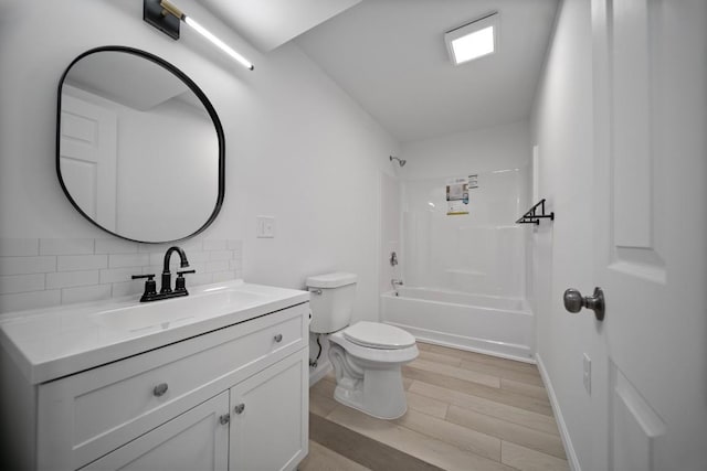 full bathroom featuring toilet, tasteful backsplash,  shower combination, vanity, and hardwood / wood-style flooring