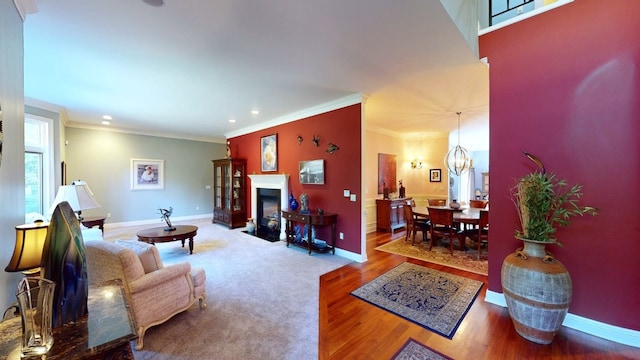 living room featuring a chandelier, hardwood / wood-style flooring, and ornamental molding