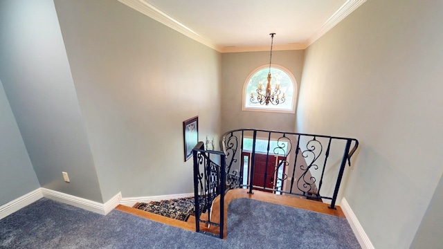 staircase with carpet flooring, crown molding, and a chandelier