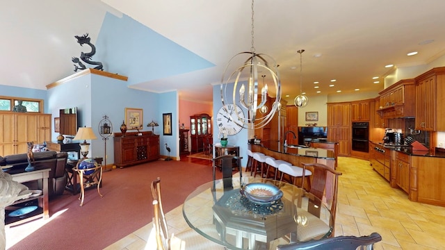 dining room featuring light carpet, a high ceiling, a notable chandelier, and sink