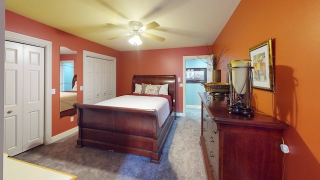 bedroom featuring carpet flooring, ceiling fan, and two closets